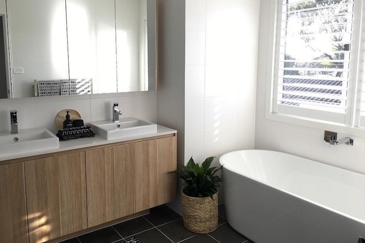 Bathroom in white and pine with black floor tiles