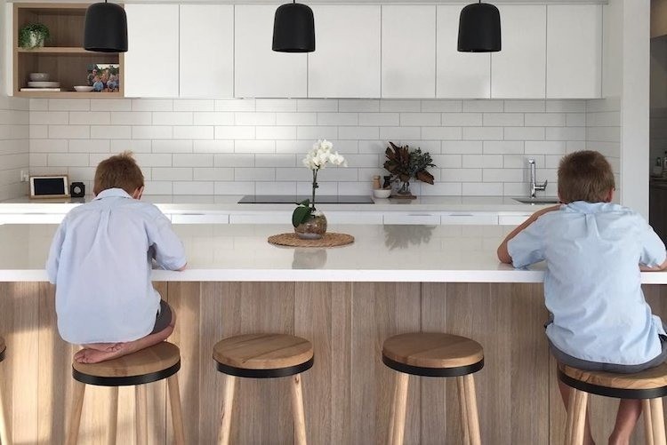 Kids sitting on stools in the kitchen built by Clarendon Homes