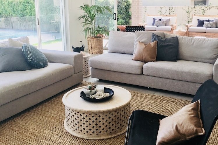 Neutral tone living area looking out onto pool in backyard